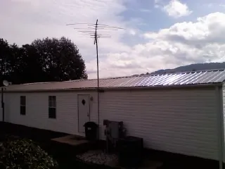 New metal roof on a single wide mobile home with a TV antenna in Palm Coast
