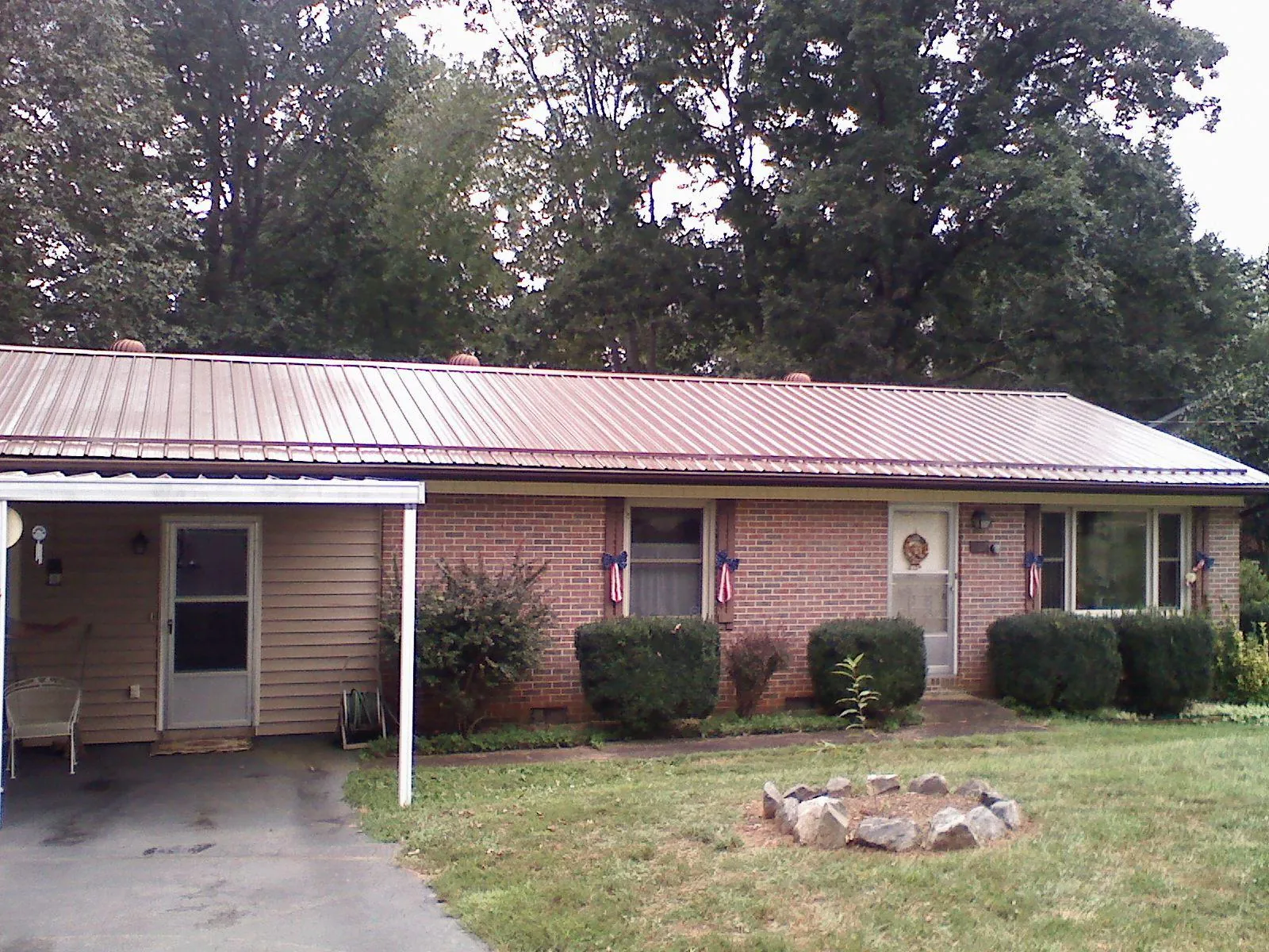 Bronze metal roof and carport on a brick ranch home — Roof Repair work by our crew in Palm Coast